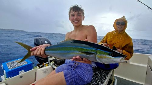 Young angler with a rainbow runner caught near the reef